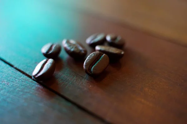 Coffee beans fall on rustic wooden table  Delicious luxury coffee beans and the aroma of morning coffee.