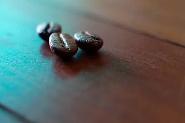 Coffee beans fall on rustic wooden table  Delicious luxury coffee beans and the aroma of morning coffee.