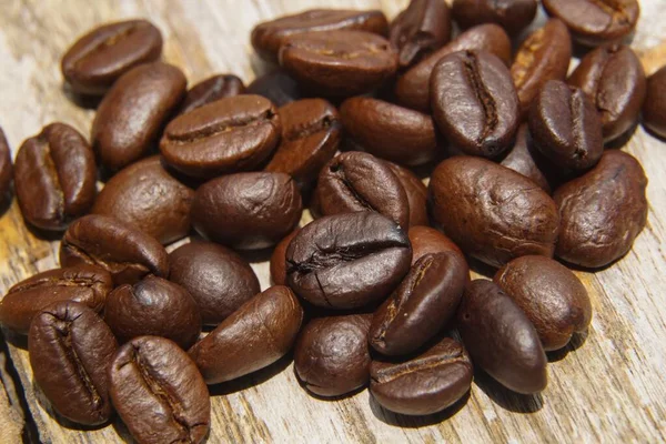 Coffee beans fall on rustic wooden table  Delicious luxury coffee beans and the aroma of morning coffee.