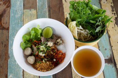 Closeup Spicy TOM YAM Pork Noodles Soup with Pork Balls, chilly pasted and lime juice  Noodles in Thai spicy tom yum soup with pork.