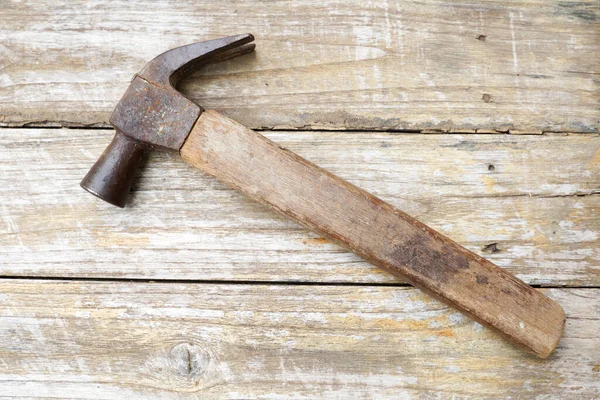 Hammer and nails on wooden background, wood and rust head iron hammer lying on wooden board with outdoor workshop.