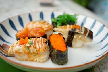 Çeşitli yüzlere sahip suşi seti basit Japon yemeğidir. Lezzetli deniz ürünleri. Suşi restoranı konsepti