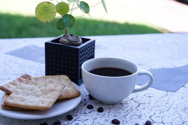 白杯中的热黑咖啡和饼干是浓烈的 搭配得很好 — 图库照片