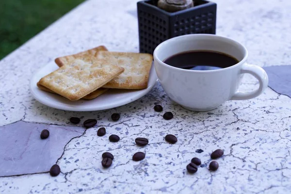 白杯中的热黑咖啡和饼干是浓烈的 搭配得很好 — 图库照片