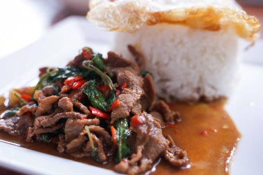 Kızarmış biftekle fesleğeni karıştırıp beyaz tabakta sade bir yumurta ile karıştırmak. Taylandlıların çok popüler olduğunu..