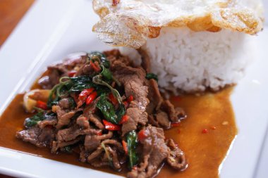 Kızarmış biftekle fesleğeni karıştırıp beyaz tabakta sade bir yumurta ile karıştırmak. Taylandlıların çok popüler olduğunu..