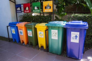 Big different color containers for sorting waste.