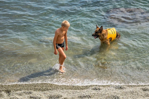 2021年9月13日 克里米亚阿卢什塔 海滩上身穿救生衣的病犬男孩和老人 — 图库照片