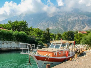 Beldibi, Antalya, Türkiye - 7 Ekim 2016: Akdeniz 'de küçük bir körfezde tekne. Arka planda Taurus Dağları bulutlarla kaplı.