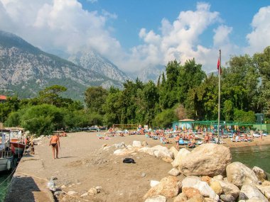 Beldibi, Antalya, Türkiye - 7 Ekim 2016: Akdeniz 'de güneş banyosu yapan kumlu ve çakıl taşlı plaj. Arka planda Taurus Dağları var..