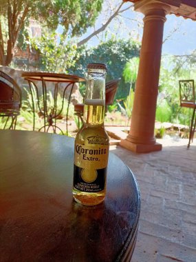 Eski ahşap masa, bir şişe ve bir bardak su.