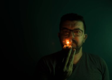 Bir insan elinde yanan bir yumru balığı alır.