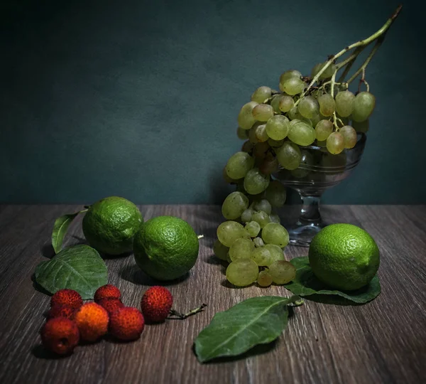 still life with fruits and vegetables on a dark wooden background