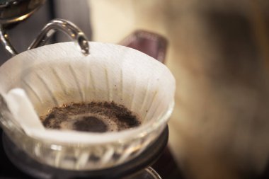 Vintage style of coffee in the morning. Close up of ground coffee in a dripper while making aroma espresso.