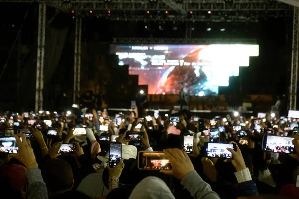 Many people with phone on stage