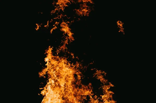 A Fire embers particles over black background. Fire sparks background. Abstract dark glitter fire particles lights. bonfire in motion blur.