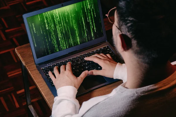 A man with computer screen with green binary matrix binary