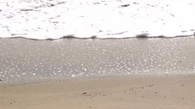 Sahilde deniz, arka plan olarak rahatlatıcı kum.