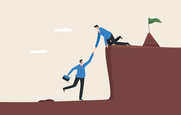 Teamwork support.Working together to achieve goals, cooperation.A business man helping an employee climb a steep cliff by hand.