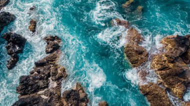 Stones, turquoise waves from above. Atlantic ocean coastline, Madeira island, Portugal. Aerial drone photo. Scenery sea background.