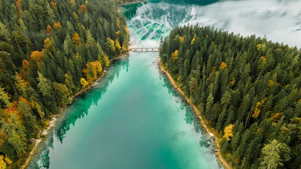 Autumn in the Bavarian mountains, Germany. Alps landscape with lake, bridge, clouds, forest, coast and turquoise water. View from above. Aerial drone outdoor photo.
