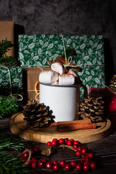 Cacao with marshmallow and Christmas gifts. New year boxes with kraft, red, green paper decoration. Still life close up. Hot drink photo.