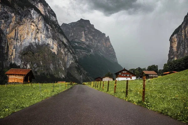 Lauterbrunnen valley, Switzerland. Swiss Alps. Road in mountains. Forest and rocks. Beautiful landscape, Europe. Village with wooden houses, traditional chalet.