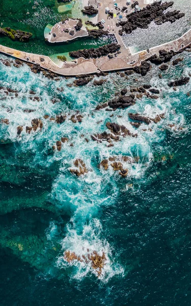 Atlantic ocean coastline with cliffs rocks and turquoise waves. Madeira island, Portugal. Aerial drone photography. Beautiful landscape. Sea background. Natural swimming pool. 