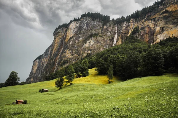 Lauterbrunnen valley, Switzerland. Swiss Alps. waterfall in mountains. Forest, fog, green meadow and low clouds. Beautiful landscape, Europe.
