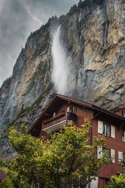 Lauterbrunnen valley, Switzerland. Swiss Alps. Cozy small house in mountains, waterfall. Forest and rocks. Beautiful landscape, Europe