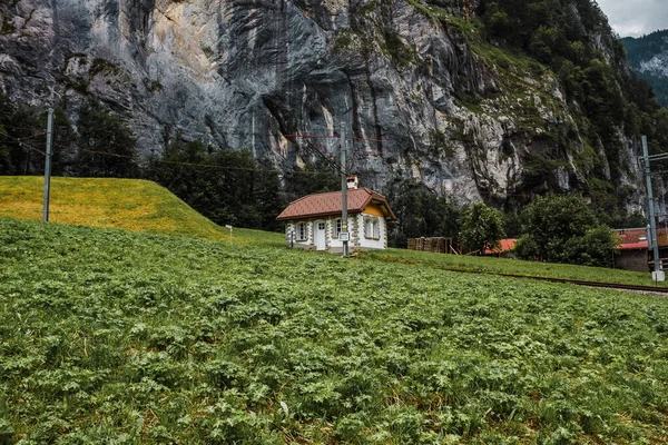 Lauterbrunnen valley, Switzerland. Swiss Alps. Small house in mountains. Forest, rocks and green meadows. Beautiful landscape, Europe. Railway Jungfraujoch.