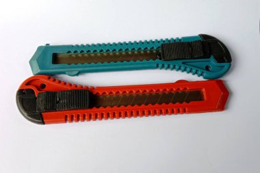 Mutfak gereçleri ve diğerleri için gri arka plana karşı mavi ve kırmızı renkli iki kesici.