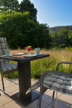 Terasta kahvaltı. Yeşil doğanın önünde. Güzel bir yaz gününde mavi gökyüzü.