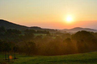 Speassart, Bavyera, Almanya 'da sabah sisi ile güneş doğuyor.