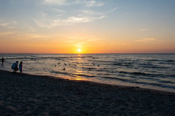 Idílio Praia Pessoas Apreciam Pôr Sol Sobre Mar Com Quebra — Fotografia de Stock