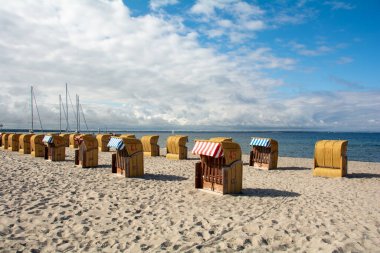 Kahverengi hasır sepetleri, Baltık Denizi kıyısında, Timmendorf Strand 'da, Almanya' nın Poel adasında, yelkenli gemi direğiyle
