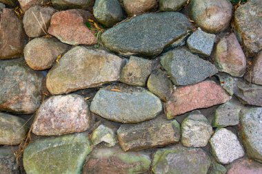 Farklı boyutlarda taşlardan yapılmış eski taş bir duvar.