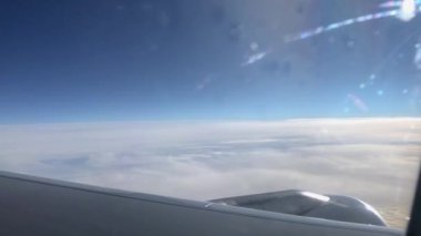 Pencereden geçen uçak kanadı. Uçakla bulutların üzerinde uçmak. Kanat ve bulutlardaki lombozdan bak.