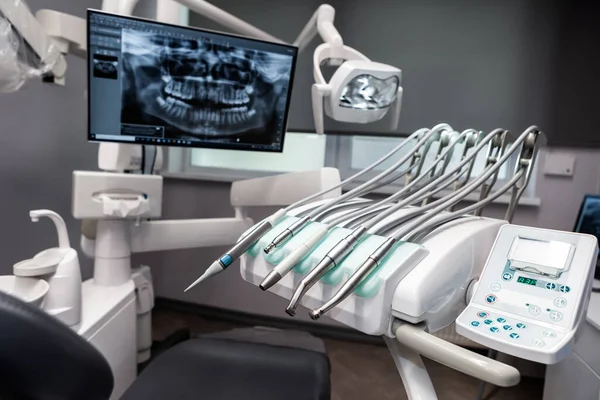 At the dentists. Dental instruments and an x-ray photo of the whole mouth shown on the screen.