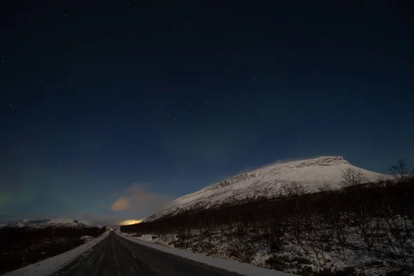 在芬兰拉普兰的基尔佩什利维 在一个无云的夜晚 北极光扫过了一条主干道 极光以绿色的形式在天空中舞动 斯堪的纳维亚魔法萨纳山 — 图库照片