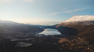 Kuzey Norveç 'in Finnmark bölgesindeki dağların arasındaki vadi göle ve komşu köye bakıyor. Manzarayı keşfediyorum. Maceralı bir hayat.
