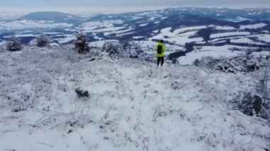 Gezgin ve yürüyüşçü Çek Cumhuriyeti 'nin Ondrejnik adlı karlı bir tepede yürüyor ve manzaranın ve temiz havanın tadını çıkarıyor. Aktif açık hava yaşam tarzı. İnsansız hava aracı görüntüleri. 4k video