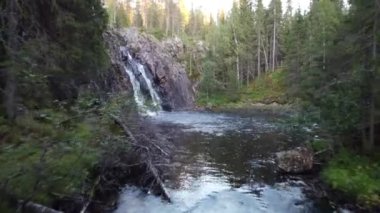 Close-up and slow motion shot of the breathtaking Hepokongas waterfall in Kainuu region, Finland. Water flowing from the rock at sunset and during the autumn season. Suomi waterfall. 4k video 