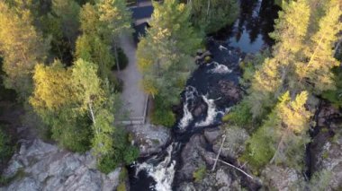 Close-up and slow motion shot of the breathtaking Hepokongas waterfall in Kainuu region, Finland. Water flowing from the rock at sunset and during the autumn season. Suomi waterfall. 4k video 