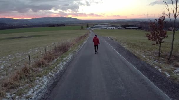 Een Man Met Een Rood Jasje Loopt Langs Weg Weg — Stockvideo