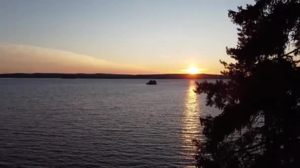 フィンランドのカイヌー地方のOulujarvi湖での日の出 針葉樹林の中をドローンで撮影し 日の出とスオミ湖の美しさをゆっくりと見せてくれます フルHdビデオ — ストック動画