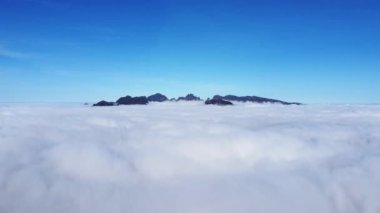 Yel değirmenlerinden Ribeira Brava 'nın manzarası ve güneşli havada Portekiz' in Madeira 'nın en yüksek dağlarının manzarası. Pico Ruivo, Pico do Arieiro, Pico Grande. Dağ sırasının havadan görünüşü. 4k video