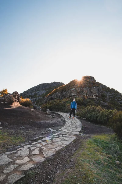 Madeiras 'ın en yüksek dağı Pico Ruivo' da bulunan Encumeada Baixa dağının altında yürüyüş rotası. Güneş Madeiran dağlarının yamacında parlıyor. Portekiz adasını keşfedin.