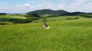 Kahverengi saçlı sporcu, bir tepenin zirvesinde sıkı çalıştıktan sonra kasıklarını esnetir ve vücudunun alt kısmını çalıştırır. Esneme ve bacaklardaki laktattan kurtulma. 4k video