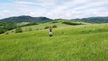 Kahverengi saçlı voleybol oyuncusu güneşli bir günde tepedeki antrenmandan önce ısınıyor. Genç bir sporcunun sağlıklı ve aktif yaşam tarzı. Atlama valeleri